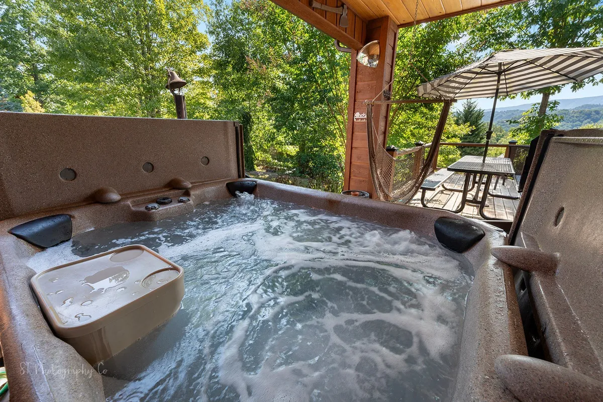 An inviting exterior patio area with a hot tub surrounded by trees—perfect for relaxing after a day of hiking or exploring. The tranquil setting highlights both the natural environment and the rejuvenation you can expect as part of your stay.