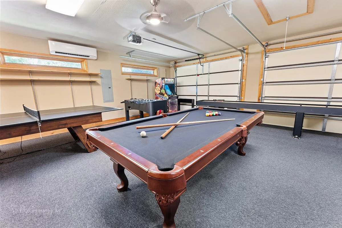 This photo showcases a playful corner of the game loft, highlighting a pool table, foosball table, and a classic arcade machine. The arrangement encourages social interaction and group tournaments, while the warm lighting and relaxed setup suggest a welcoming atmosphere.